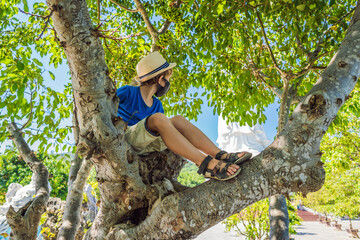 Coronavirus outbreak concept. Boy tourist in Da Nang, Vietnam wears a medical mask during a new...
