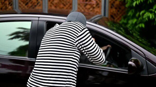 Robbery of a woman in a car. Thief use knife to threaten for steal money in a purse.