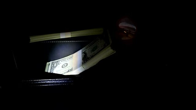 Thief opens the digital safe. Stealing money and valuables at dark night.