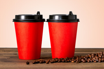 Two paper cup of coffee and coffee beans on wooden table. Coffee to go concept.