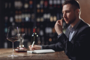 Professional sommelier examining smell of wine cork and making notes aroma degustation card