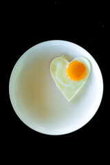 omelet heart-shaped breakfast menu on the white dish breakfast isolated on black background taken by top view. 