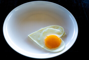 omelet heart-shaped breakfast menu on the white dish breakfast isolated on black background taken by top view. 