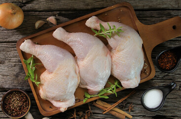 fresh chicken meat with rosemary and spices on wooden board.