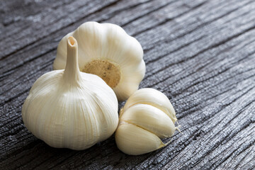Raw Garlic Bulb and Cloves on dark wooden background, Garlic can help reduce the risk of many diseases, Classified as healthy food.