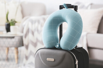 Travel pillow and suitcase in room