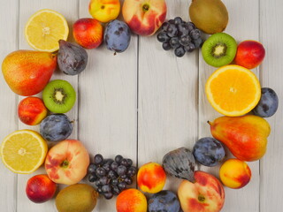 A frame of ripe various fruits on a white background of boards. Close-up. Proper nutrition. Space for text.