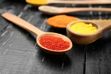 Many spoons with different spices on table