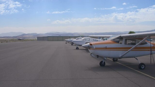 A line of airplanes at a small desert airport, establishing shot, LED Wall or Greenscreen Background, 28mm 4k