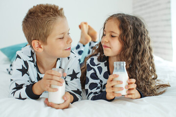 Children drink milk. Boy and girl at home. High quality photo.