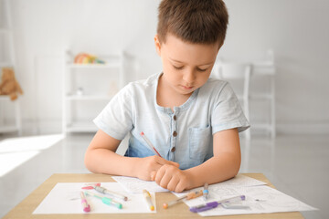 Cute little boy coloring pictures at home
