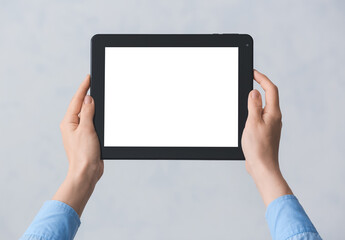 Hands with modern tablet computer on grey background