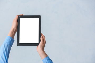 Hands with modern tablet computer on grey background