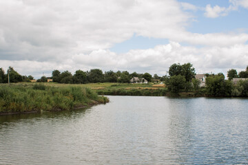 Fototapeta premium small lake in a village in a meadow