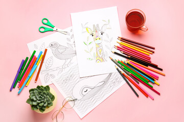 Coloring pictures, markers and pencils on table