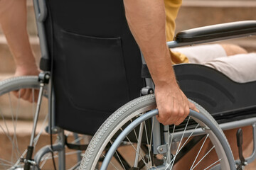Obraz premium Young man in wheelchair outdoors, closeup