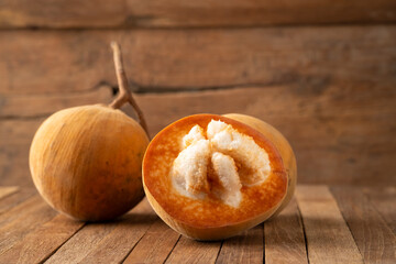 sliced santol fruit on wooden background