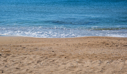 Sandy beach, ripples rolling on the coast, calm sea water background