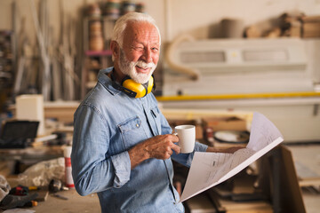 Likeable older carpenter is looking at the camera and winking