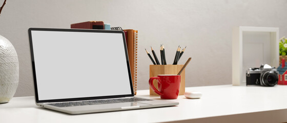 Computer laptop with clipping path on white table with stationery and decorations in home office