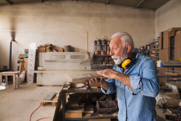 Carpenter blowing sawdust off wooden board