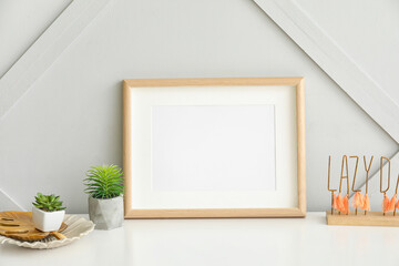 Photo frame with houseplants on table