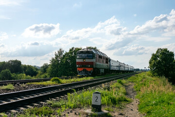 Obraz premium Nieaktualny pociąg pasażerski poza miastem.