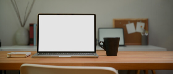 Portable workspace with laptop, mug and stationery on wooden table, clipping path.
