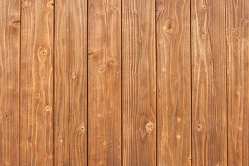 The wooden fence is brown in color with a distinct texture. 