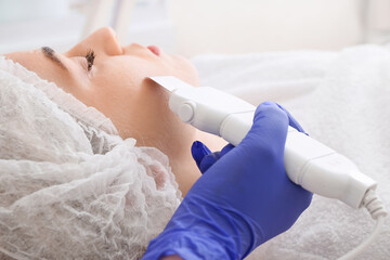 Woman undergoing procedure of facial peeling in beauty salon