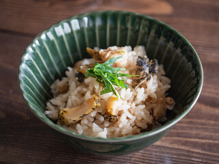 大葉が乗った灯台つぶ貝の炊き込みご飯のクローズアップ。
