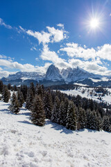 Beautiful mountain valley in the resort of Val Gardena Italy. The bright spring sun shines, illuminating coniferous trees and white snow.