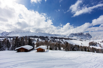 A house in the mountains, a wide panorama of the snow cover of the mountain peaks. Spring Sunny day in the Alpine mountains with clear sky and pure white snow