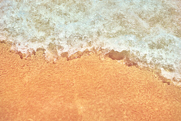 Sea wave on the sand beach, soft focus. Summer background