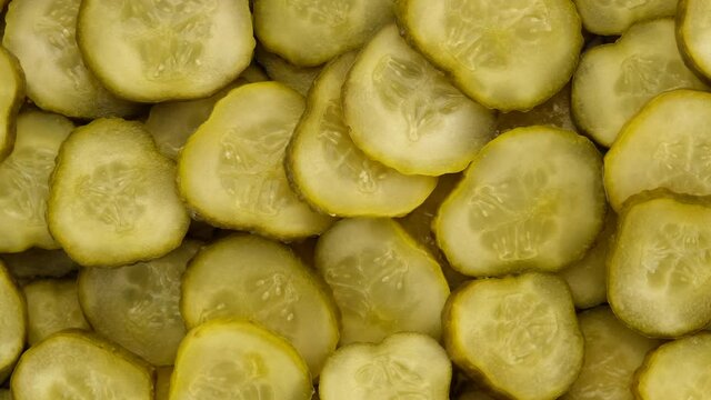 sliced dill pickles for hamburger top view rotating
