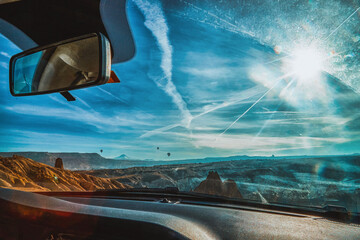 View from car window on the road and strange landscape with a valley, mountains and blue sky with clouds. Landscape through windscreen in Cappadocia in Turkey