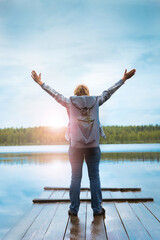 A woman with a backpack is on the lake in the park.