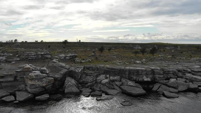 Drone flying over rocky Baltic coastline near Asunden Rauk Field Sweden