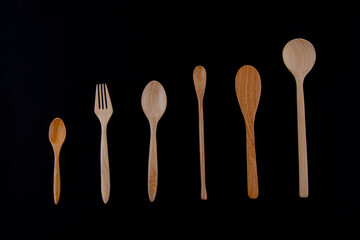 Kitchenware set of wooden spoon and wooden fork isolated on black background 