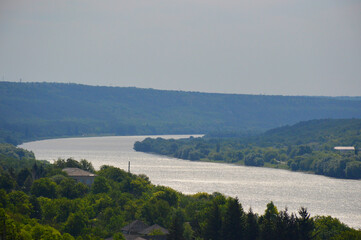 river bend and forest along the coast. the sky is covered with bluish haze