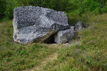 a small manhole covered with a large limestone boulder, the entrance to the cave