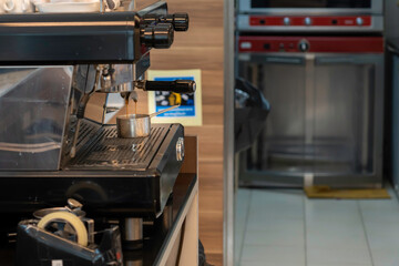 Coffee extraction from professional coffee machine in to stainless steel cup.