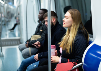 Portrait of casual people wearing warm jackets riding subway on way to work on winter day