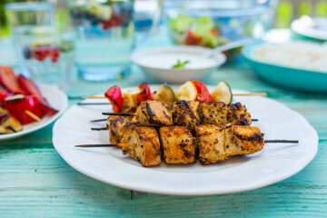 Chicken skewers and grilled colorful vegetables. Greek food.