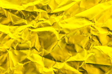 Gold foil texture background, pattern of yellow wrapping paper with crumpled and wavy.
