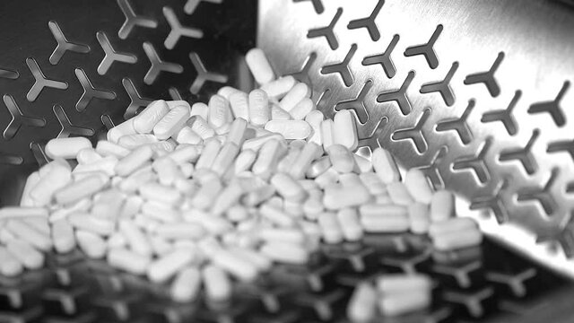 Cinematic footage of Pills, tablets and caplets on a production plant