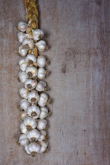 Fresh Harvesting garlic from out of  the garden. braided garlic or Garlic string. Harvested vegetables, organic. Decorative food at wooden background.