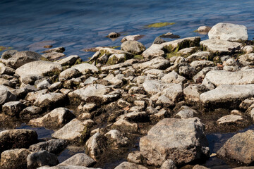The rocky shore of the lake in the afternoon.