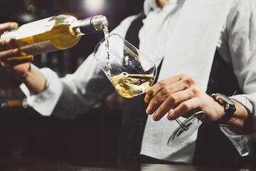 White wine is poured into a glass, close-up.