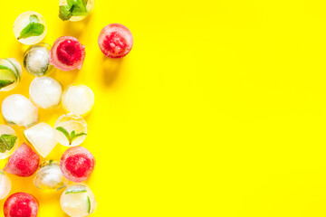 Ice cubes with berries and mint top view frame copy space